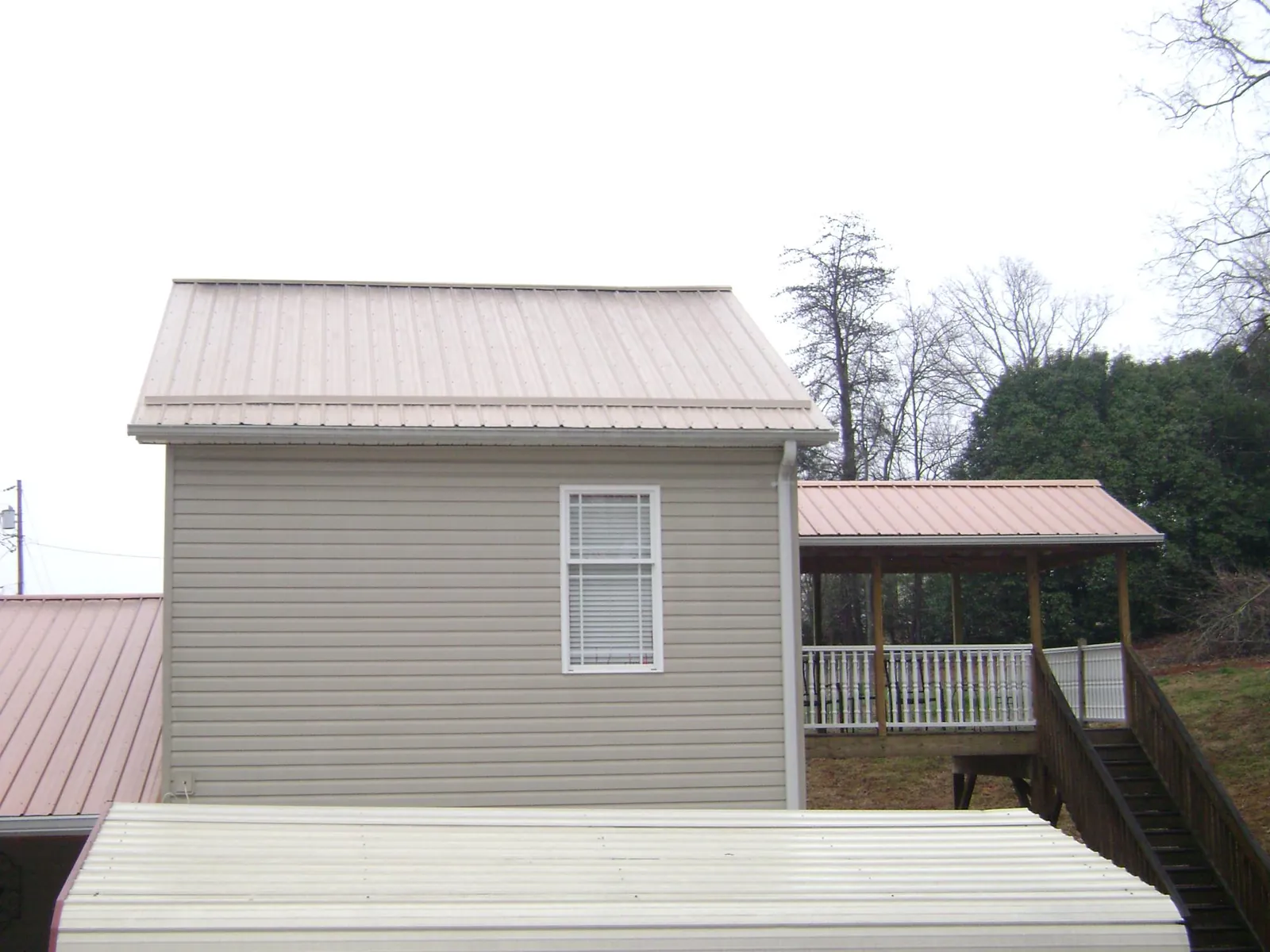 Tan metal roofs on a two story addition and attached porch, from a Roof Replacement job in Las Vegas